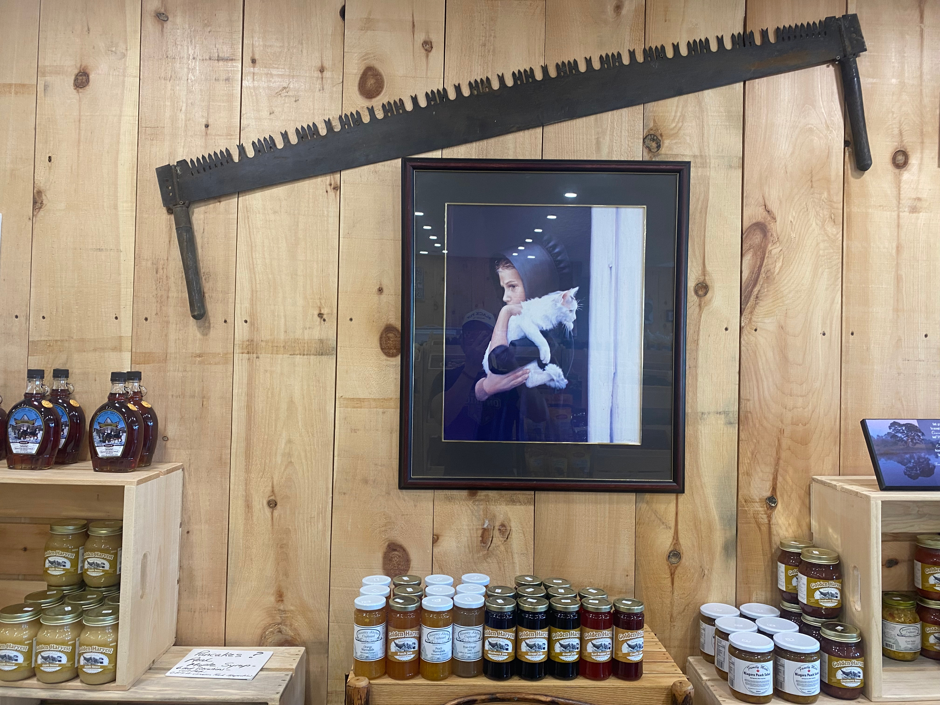 Heritage photo and antique saw decorating the market interior with local preserves