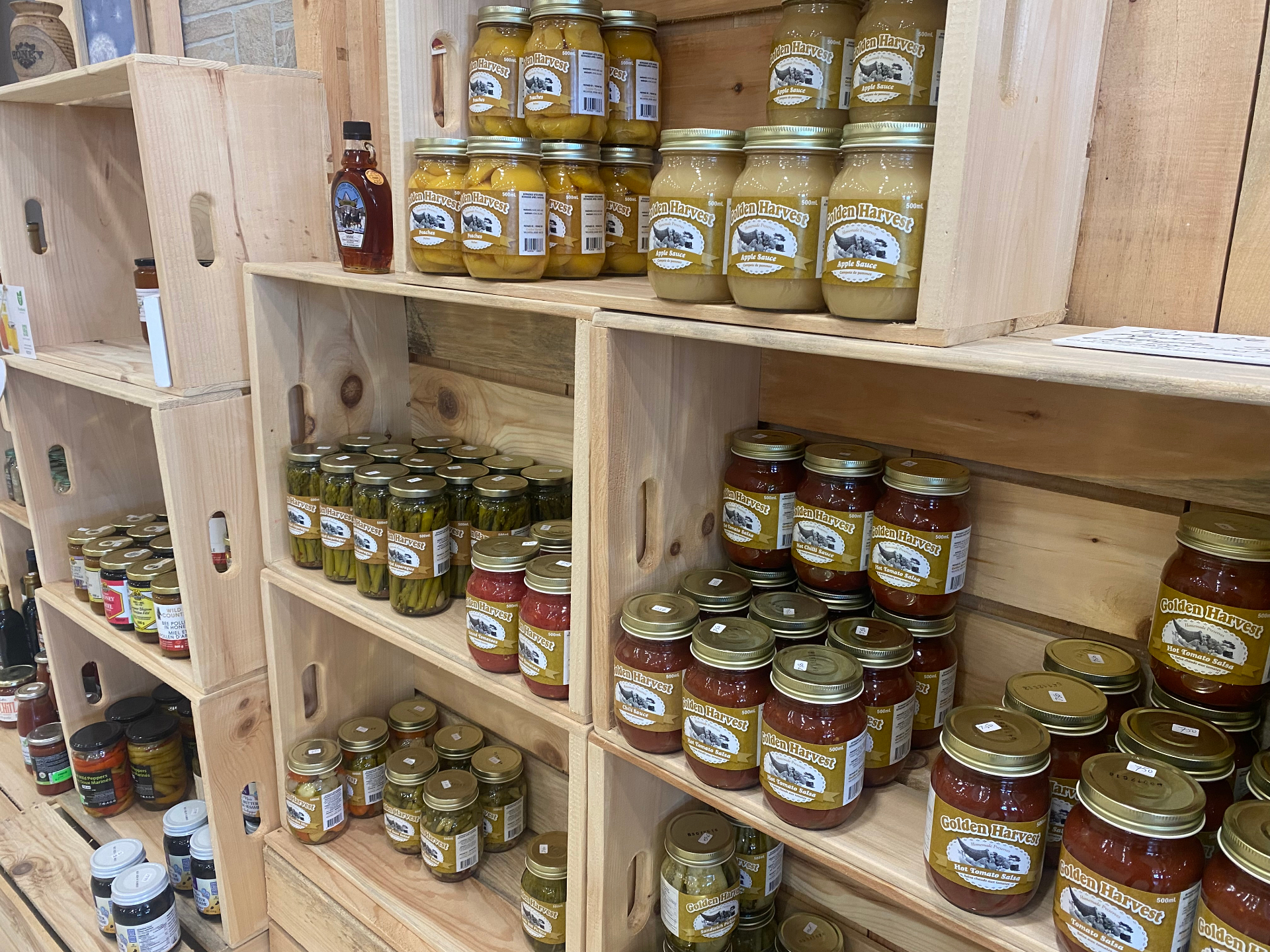 Shelves of Golden Harvest preserves, salsas and pickles in mason jars